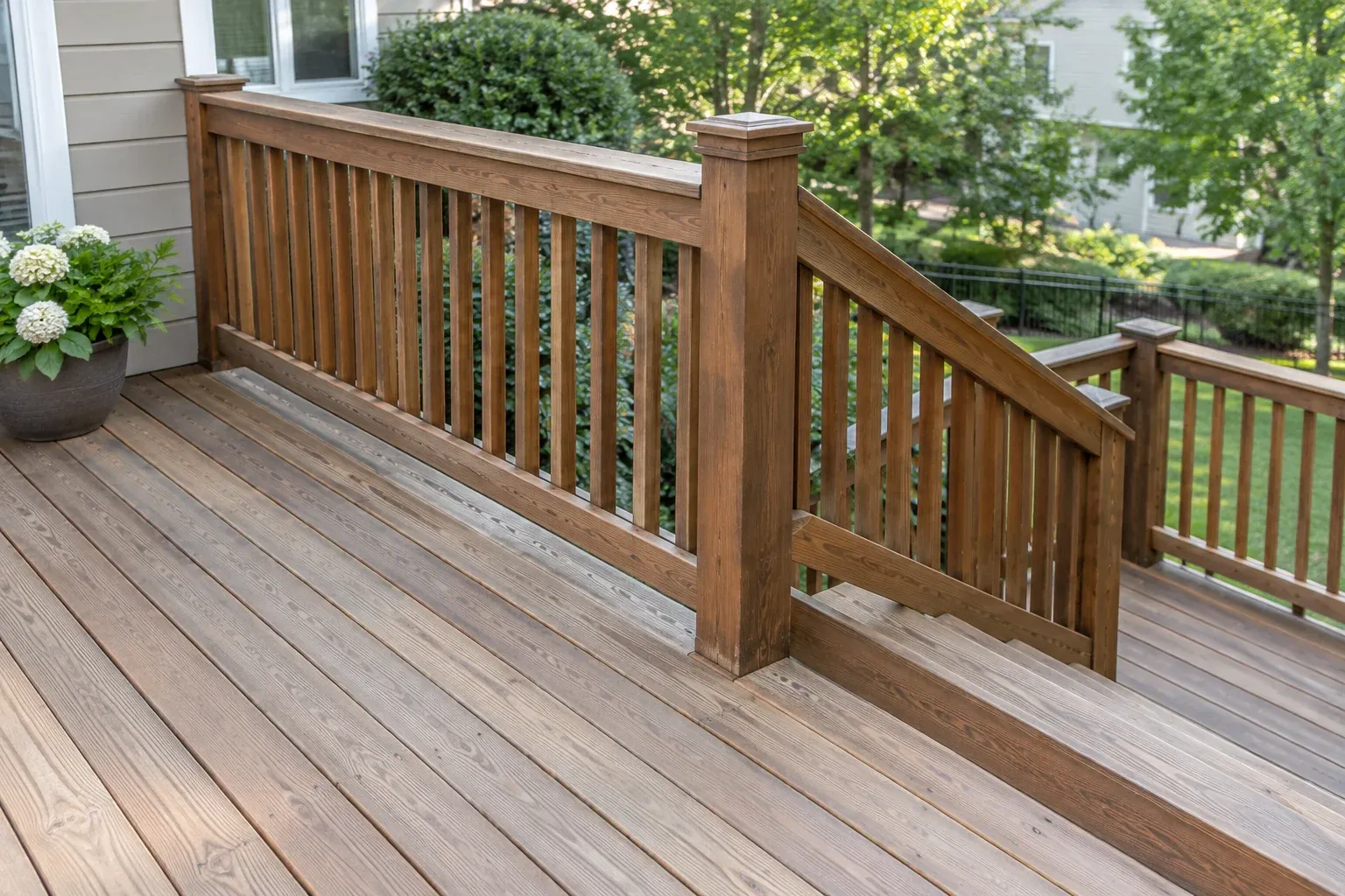 Deck boards, railing, and stairs with different levels of existing stain wear.