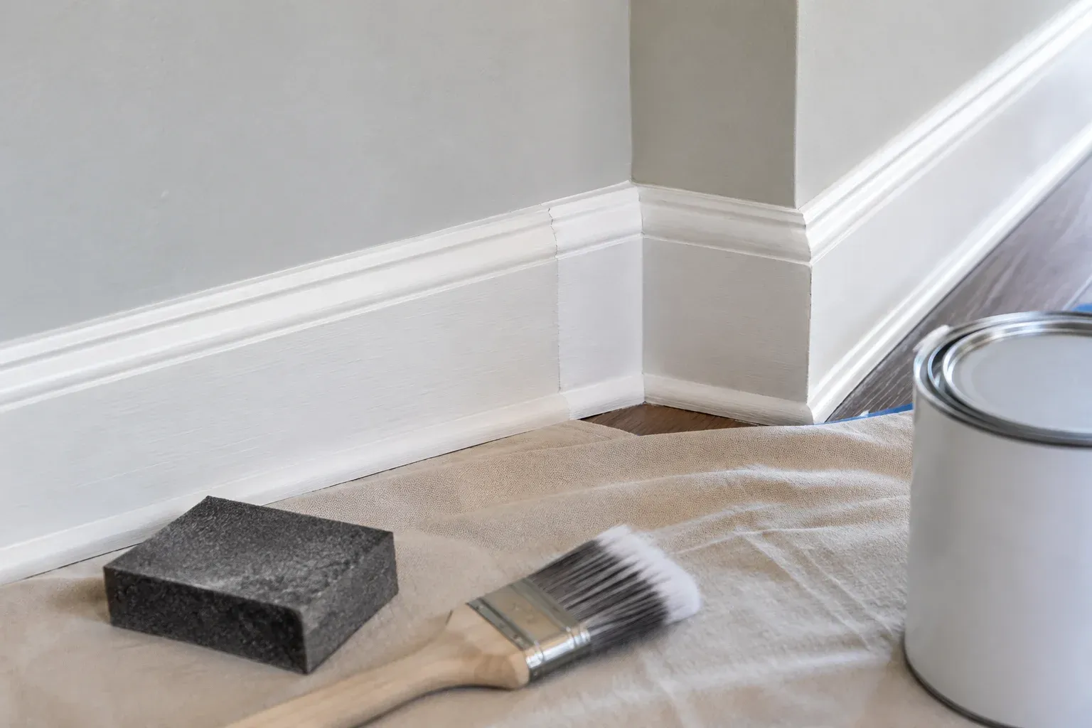 A fitted and primed baseboard repair awaiting repainting along the wall run.